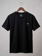 Black t-shirt with a logo on a hanger against a gray background