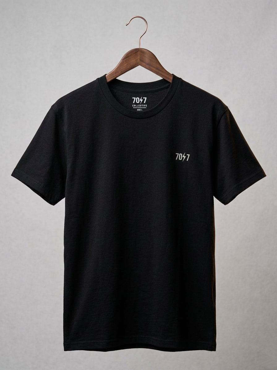 Black t-shirt with a logo on a hanger against a gray background