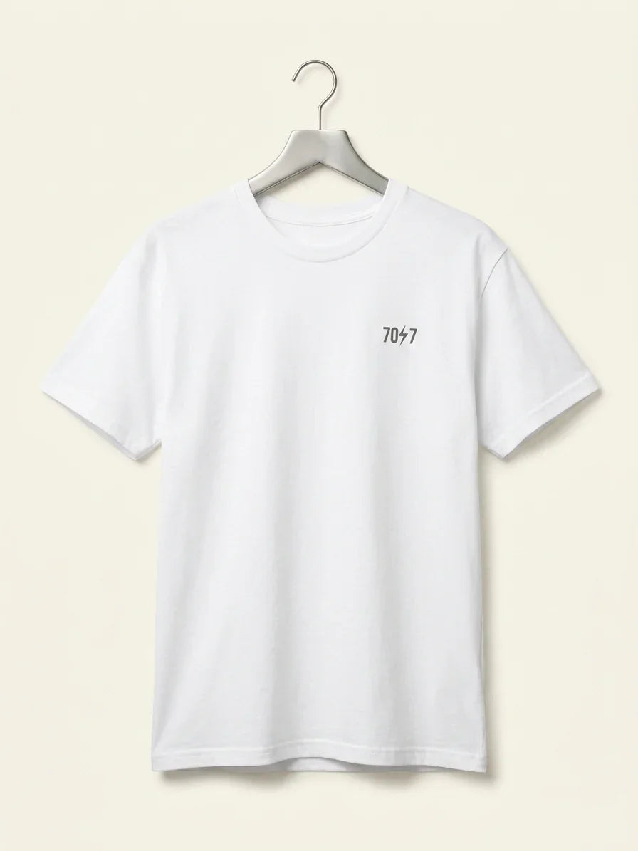 White t-shirt with a logo on a hanger against a beige background